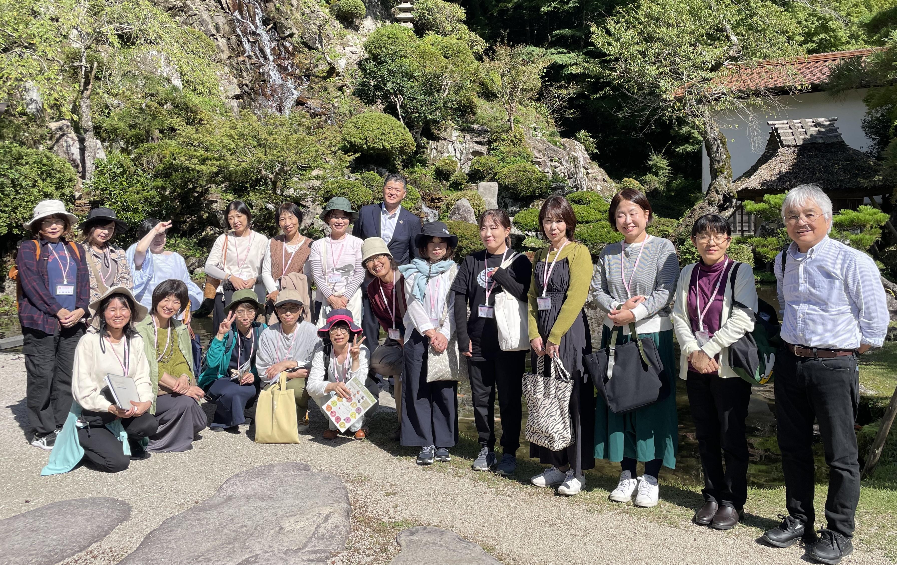 櫻井家の庭園で記念撮影をする越野本部長(後列中央)と尾方講師(前列右)と参加者.jpeg