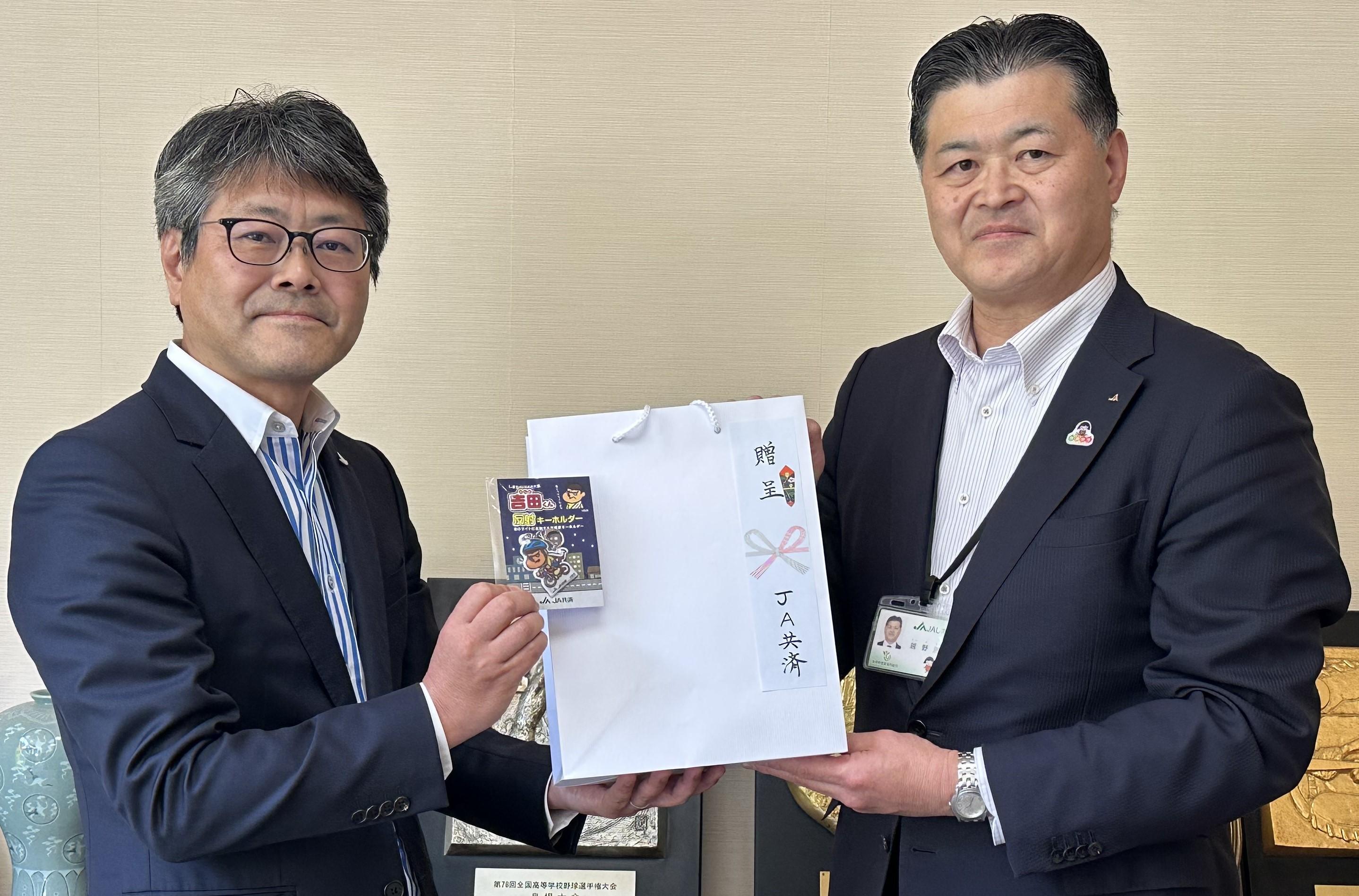 反射材を受け取る小山内校長(左)と越野本部長.jpeg