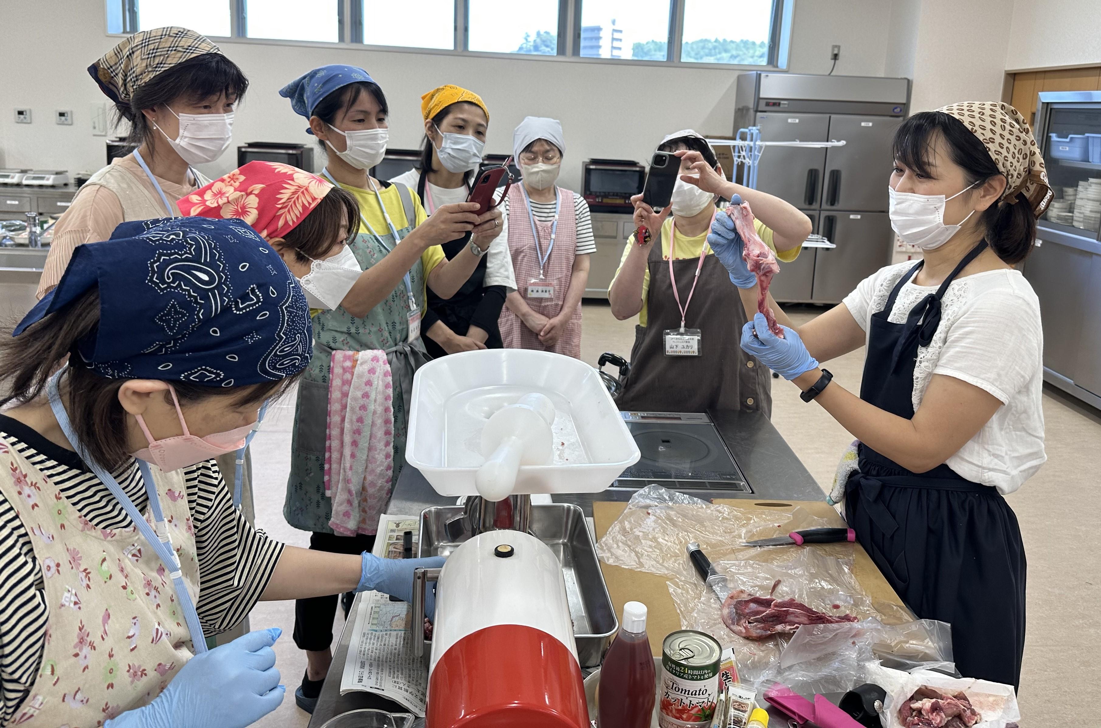 ウデ肉から取り外した骨を見せる森脇代表社員(右).jpeg